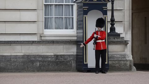 Buckingham palace, London, United Kingdom, June 2018. The guard, during his turn, marches to release his legs and then resume his position of surveillance, remaining motionless.