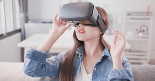 woman sit on sofa and wear virtual reality headset happily