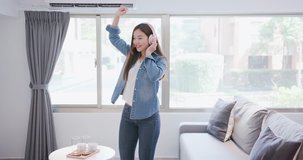 woman listen music and dance happily at home