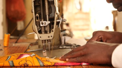 Tailor at work with sewing machine in Senegal, Africa. Close up hands.