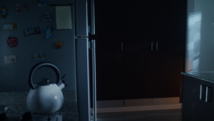 African american woman doing midnight snack at home. She eats a sandwich and looks for food into the refrigerator at night.