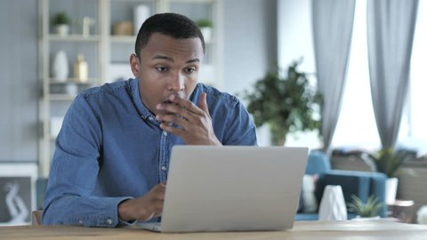 Shocked, Stunned Young African Man Wondering and Working on Laptop