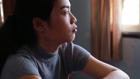 depression asian woman is sad and stress in bedroom, close up at face