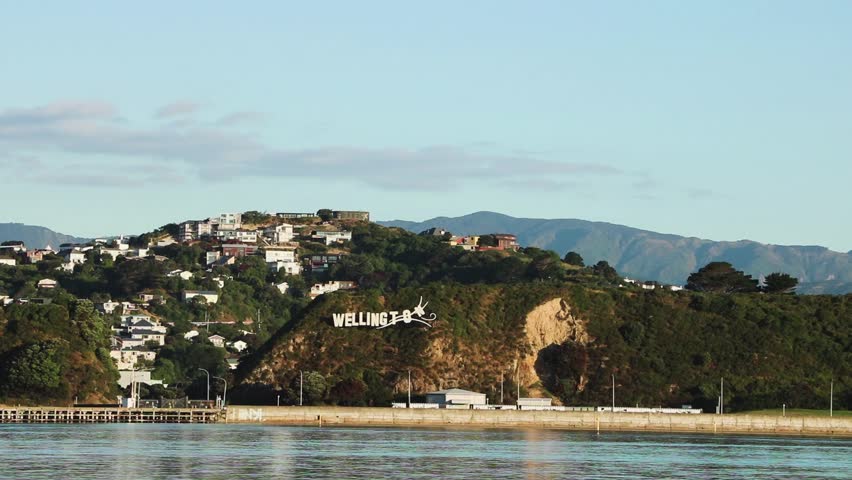 Plane landing at Wellington airport, New Zealand. Wellington welcome sign at sunset.
