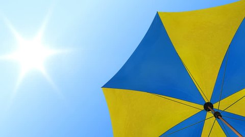 Sun umbrella rotating under summer sunny sky