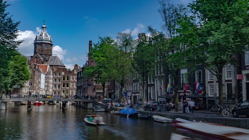 Amsterdam, Netherlands - June 1, 2018. Hyperlapse Timelapse in Amsterdam City Center with Church Architecture and Water Canal. 