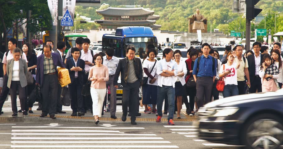 Crowd of people walking during the rush hours with Gwanghwamun Plaze in background, Seoul, South Korea Royalty-Free Stock Footage #1012768100