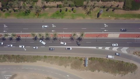 Car crash on a highway - Police car blocking the left lanes, to protect a black car with severe impact to the front, while diverted traffic passing slowly to the right. Top down aerial footage.