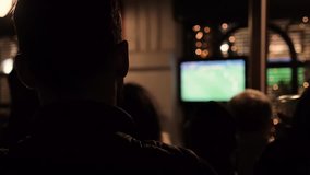 Man watching a football game on TV in a bar
