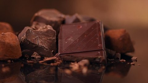 Assorted Chocolate Candies. Chocolate Sweets. Candy Design over dark Background. Various Chocolates. Confectionery. Slow motion 4K UHD video