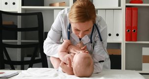 pediatrician playing with child lying on table.