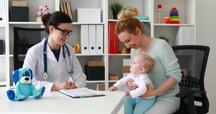 pediatrician sitting on workplace in office telling patient diagnosis.