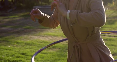 woman drops hoola hoop from waist - side profile - slow motion
