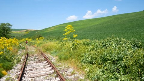 walking along abandoned railway track in Irpinia, Italy, crossing wheat fields