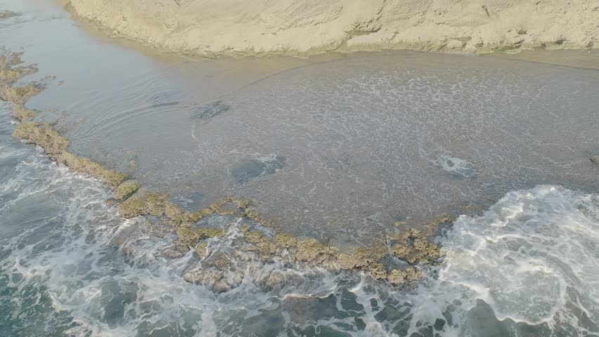 Waves crashing on rocky shore, 4k aerial drone footage 60p raw flat ungraded dlog