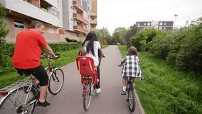 Rear View of a Happy Family Riding Bicycles. They Get a Lot of Fun Riding Together.