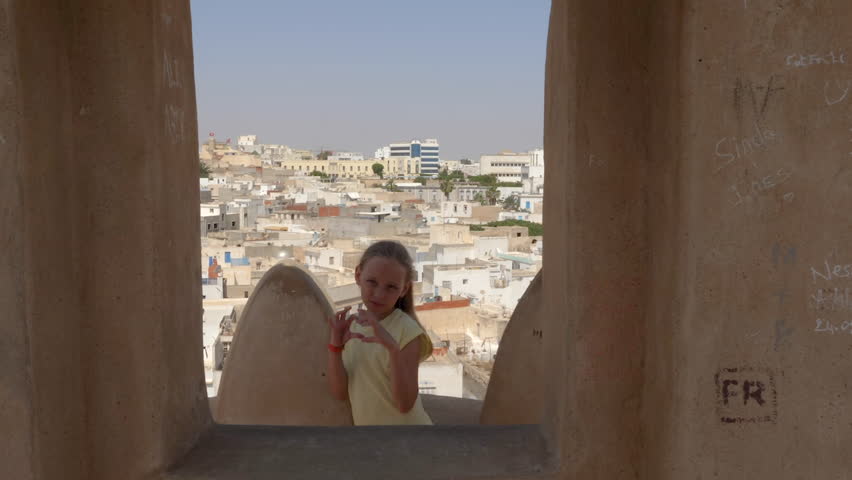 Young girl dancing joking dance against arabian town on background