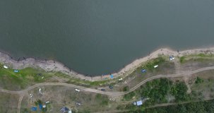 Aerial view of group of fishermen with equipment ready for sport fishing. Top view of river bank with people located at same distance