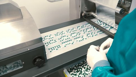 Worker control the process of sorting capsules into packages