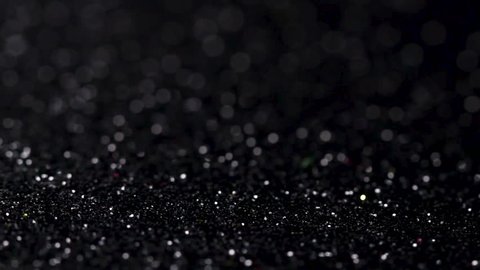 Black glitter texture rotating. Abstract shiny background.