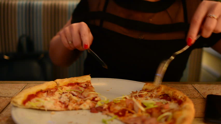 Girl eating pizza in a cafe | Shutterstock HD Video #1012828484