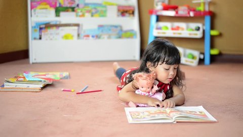 A cute little child Asian girl doing homework and reading a book. Kid enjoy learning with happiness at home. Clever,Education and smart learning concept