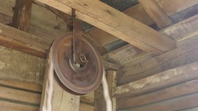 Rotating of of pulley in wooden water house 4K footage