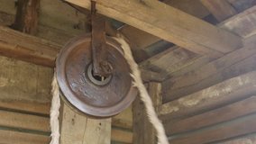 Ancient pulley rotation in water well house slow-mo footage