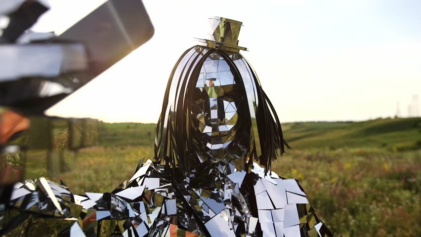 Woman in a mirror suit make selfie. sunset oudoor