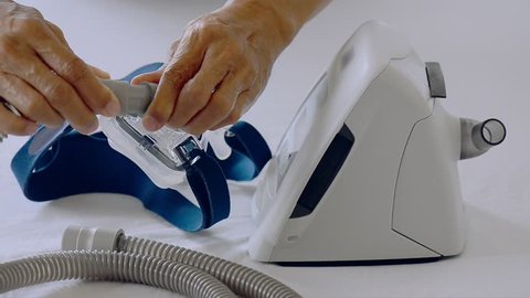 Man hands assembling patient tube to cpap mask and cpap machine in white background, hd video selective focus.
Cpap installation .