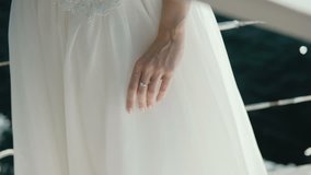 Woman's hand and white dress stands on the yacht on sunny day sailboat in the Adriatic Sea in Montenegro POV. Slow motion