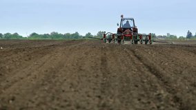 Tractor sown with corn planter ; Spring planting corn with a tractor and a sowing machine,video clip