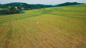 happy child playing together with ball in football on summer day, green grass and field background, Drone 4K Video