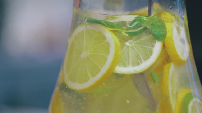 Stirring Icy Lemon Water with Thyme as Refreshment for House Party | Shutterstock HD Video #1012851656