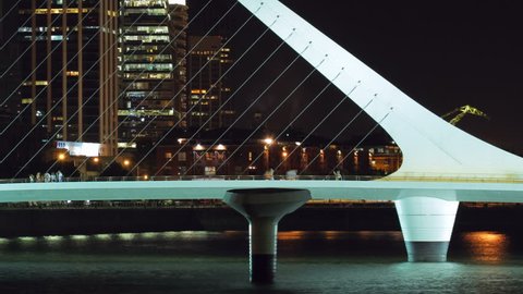 Puente de la Mujer footbridge and cityscape of Buenos Aires, Argentina, from Puerto Madero harbor at night. Photo time-lapse with cg-pan (1080p, DSLR).