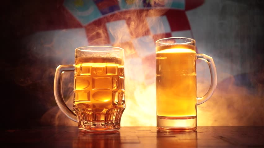 Two friends toasting (clinking) with glasses of light beer at the pub. Beautiful background with blurred view of flag of Croatia. Support your country with beer concept. Selective focus