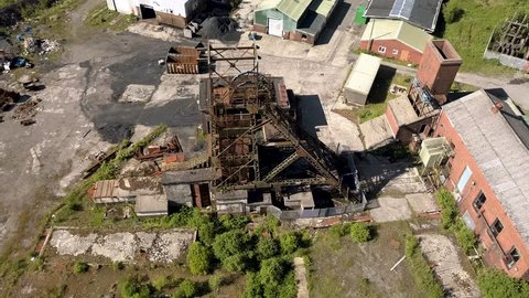 Aerial drone view circling the tower and wheel of the lift of an abandoned coal mine (Tower Colliery)