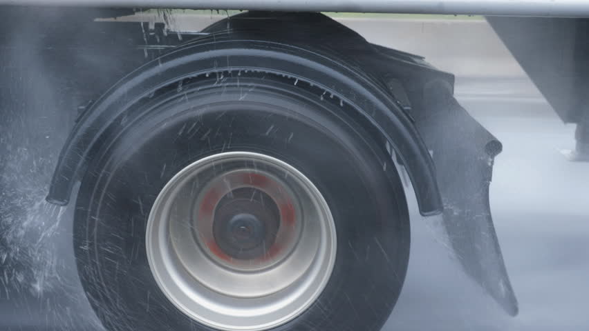 Passing truck on very rainy highway. Detail of wheel and water drops. Royalty-Free Stock Footage #1012864109
