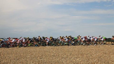Vendeuvre-sur-Barse, France - 6 July, 2017: Slightly out of focus and blurred HD footage of the peloton passing through a region of wheat fields during the stage 6 of Tour de France 2017.