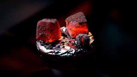 Coconut coals for a hookah pipe slowly wither away on top of a bowl of sheesha. Time-lapsed video