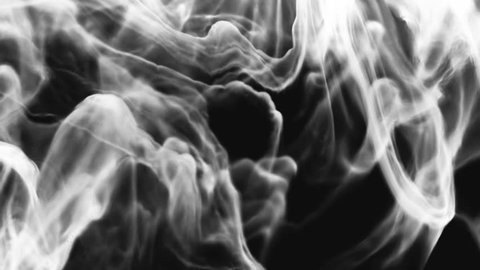 Billows of white burning turbulent smoke rise through frame against black background