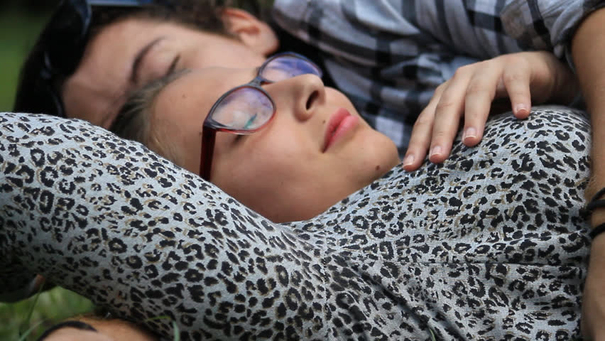 Medellin, Colombia - May 24, 2018: A young couple lying on the lawn embraces with love