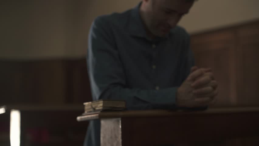 Devote man kneeling in the Church alone and praying, he is meditating with hands clasped: Christianity, religion and faith concept | Shutterstock HD Video #1012877231