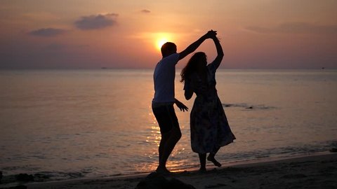 A romantic date on the beach and sunset, a man and a woman dance a slow dance. HD, 1920x1080, slow motion
