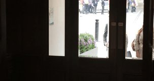 Front view of two business people walking in the front door of a hotel from a business meeting.