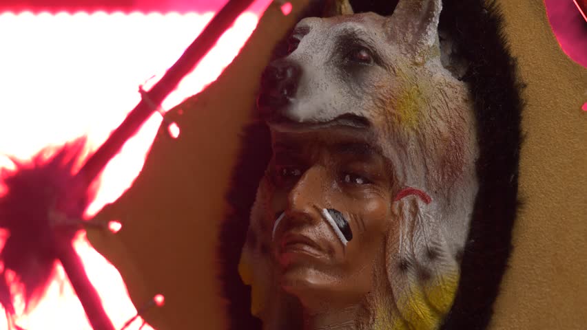 Native american indian art showing the figure of a chief wearing a wolf ornament on his head.