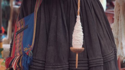 Peruvian girl weaving alpaca wool in Peru