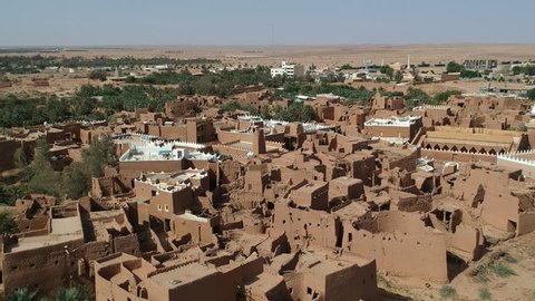Riyadh / Saudi Arabia - May 2018: Drone shot over restored Ushaiger Ruins, a touristic mud village an hour from the capital.  Flying backwards to reveal more mudhouses.