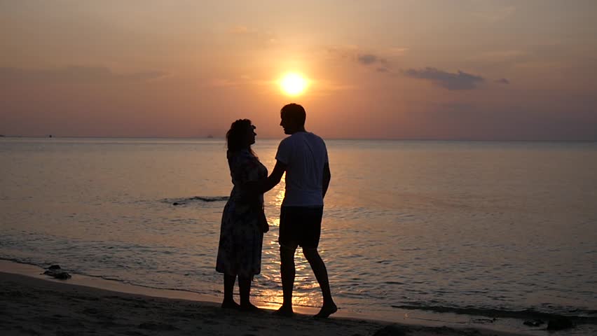 Romantic dances of a couple in love on the beach against a beautiful sunset. HD, 1920x1080, slow motion Royalty-Free Stock Footage #1012912646