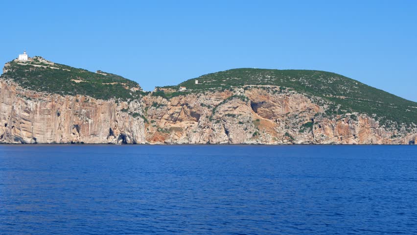 View of Capo Caccia cliff and lighthouse. Shot from a boat.